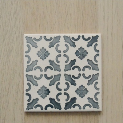Azulejo quadrado com padrão floral cinza sobre fundo branco