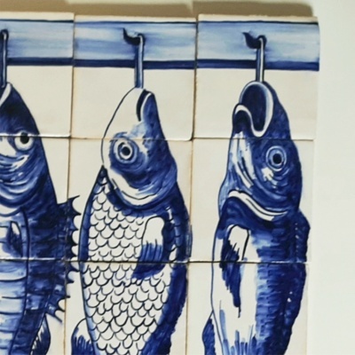 Painel de azulejos decorativos com peixe azul em fundo branco