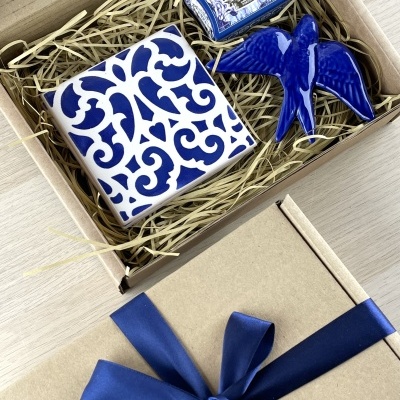 Gift box with ceramic tile, ceramic bird figurine, and a small labeled box
