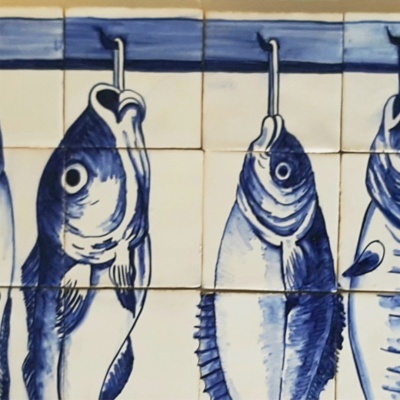 Azulejos azuis e brancos com desenhos de peixes pendurados