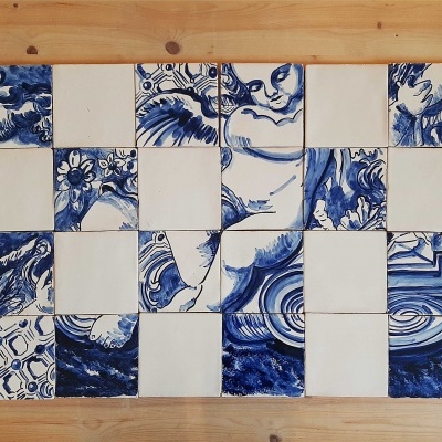 Azulejos quadrados azuis e brancos com padrões decorativos sobre superfície de madeira