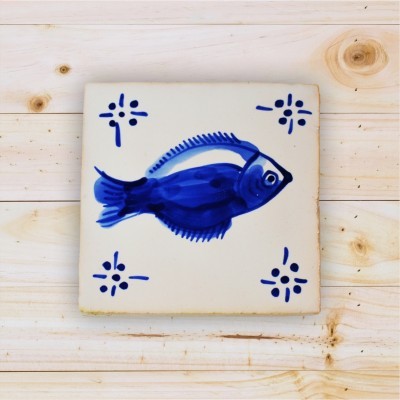 Azulejo branco com desenho de peixe azul e padrões decorativos em madeira clara
