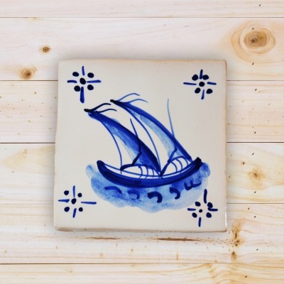 Azulejo cerâmico com desenho de barco azul e branco sobre fundo branco