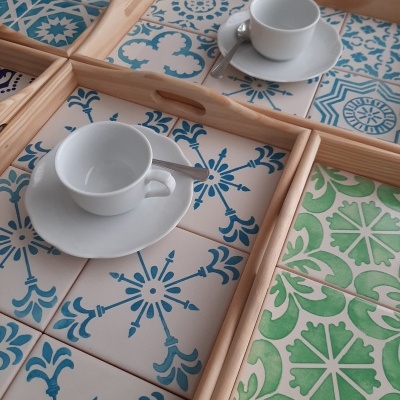 Bandejas de madeira com azulejos decorativos e chávenas de chá brancas