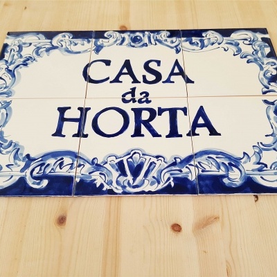 placa decorativa de azulejos com texto CASA da HORTA sobre madeira