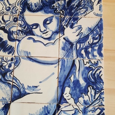 Painel de azulejos azuis e brancos com anjo segurando pena
