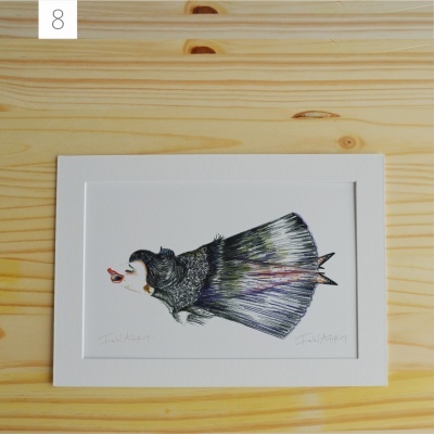 Ilustração de peixe colorido em suporte branco sobre mesa de madeira clara