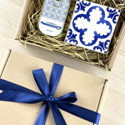 Gift box with milk chocolate sardines tin and blue white ceramic tile