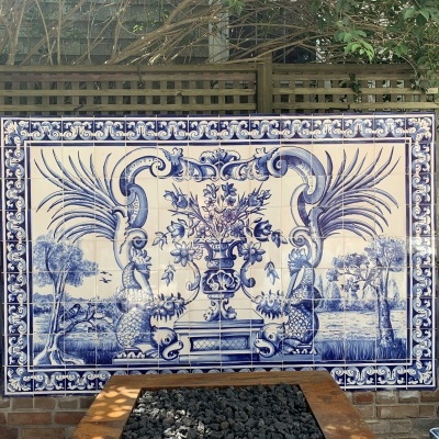 Painel decorativo em azulejos azul e branco com flores e peixes ao ar livre