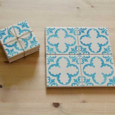 Azulejos decorativos azuis e brancos sobre mesa de madeira clara