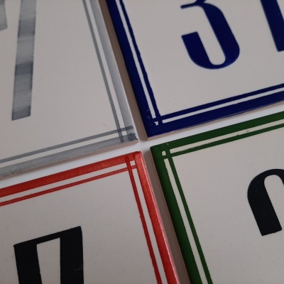 Placas quadradas de cerâmica com números impressos de várias cores