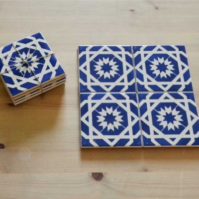 Azulejos decorativos em cerâmica com padrão azul e branco sobre madeira clara