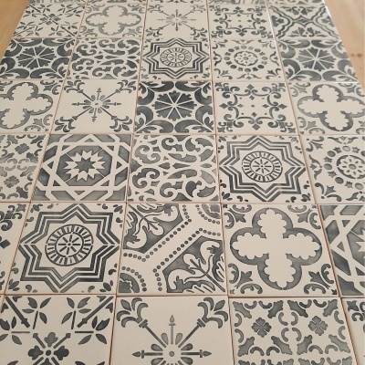 Azulejos porcelânicos cinza e bege com padrões geométricos e florais