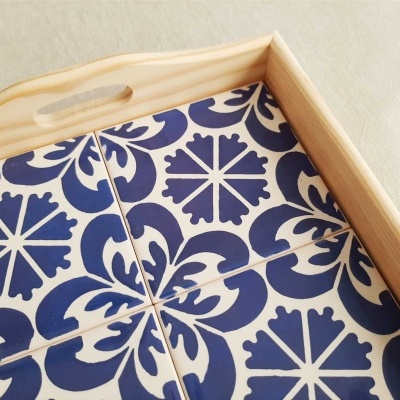 Tabuleiro em madeira com azulejos azuis e brancos com padrão geométrico.
