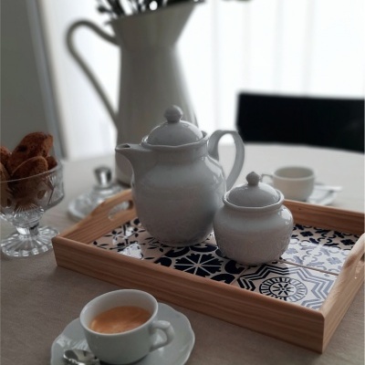 Conjunto de chávenas e bule branco em bandeja de madeira decorada, café expresso, jarro com flores e biscoitos 