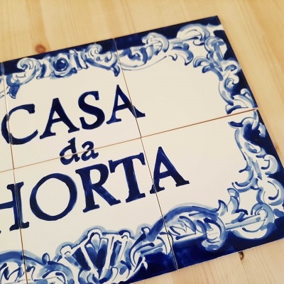 Placa de azulejos portugueses brancos com texto azul CASA da HORTA e decoração azul barroca