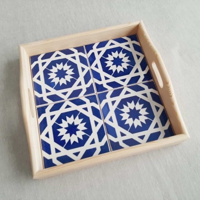 Tabuleiro de madeira com azulejos azuis e brancos com padrão geométrico