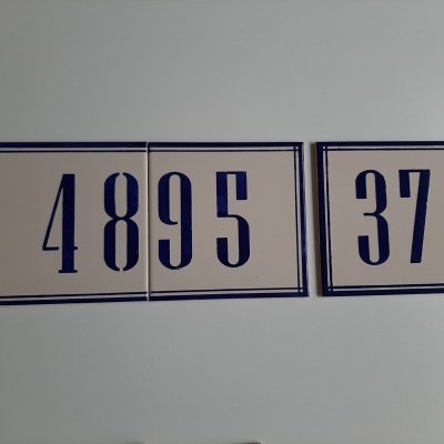 Placas de azulejo com números 4895 e 37 em azul sobre fundo branco