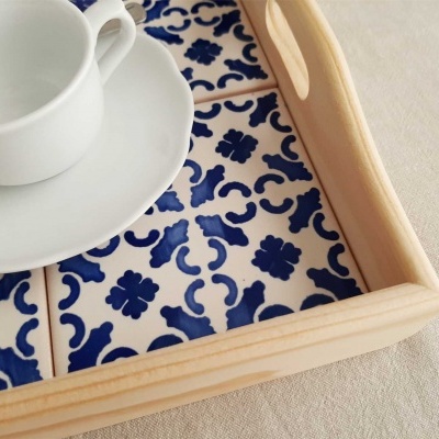 Tabuleiro de madeira com azulejos decorativos azuis e brancos, chávena e pires brancos