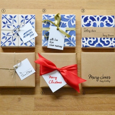 Presentes embalados com papel castanho e azul e branco com etiquetas de texto