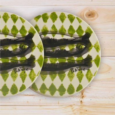 Pratos de cerâmica com padrão verde e desenho de peixes preto sobre madeira clara