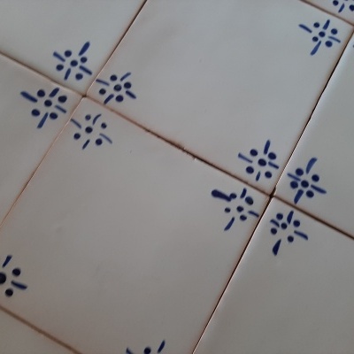 Azulejos brancos quadrados com padrão azul decorativo em junções