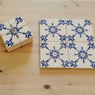 Azulejos cerâmicos azuis e brancos com padrão floral e geométrico sobre tampo de madeira