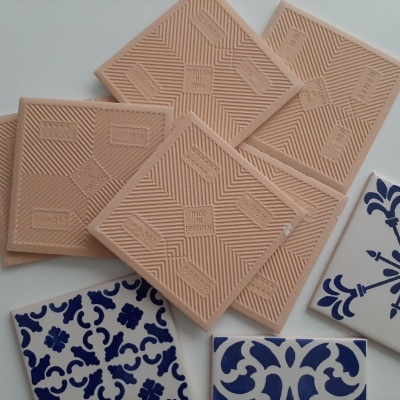 Azulejos decorativos bege com relevo e azulejos azuis e brancos com padrões tradicionais