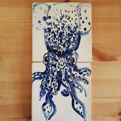 Dois azulejos pintados com desenho de polvo azul sobre fundo branco