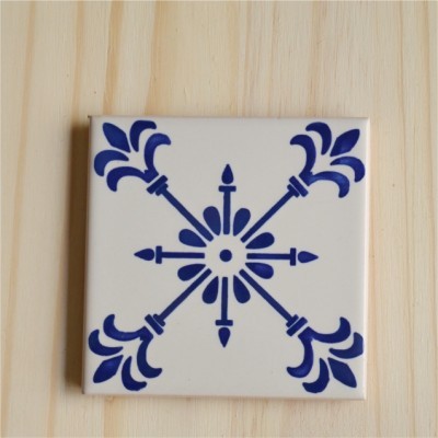 Azulejo quadrado cerâmico branco com padrão azul em forma de cruz estilizada