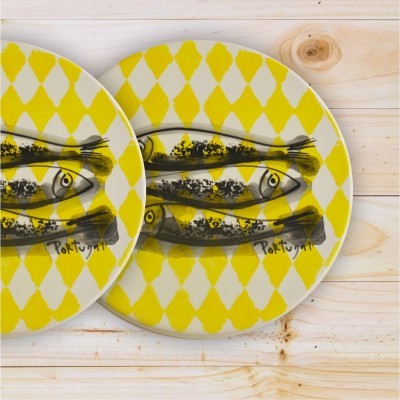 Pratos redondos em cerâmica com padrão amarelo e desenho de peixes pretos em fundo branco