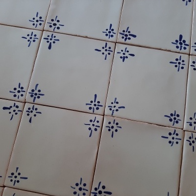 Azulejos quadrados brancos com desenhos azuis em padrão cruzado