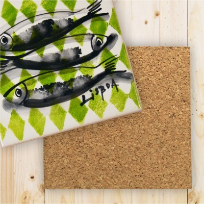 Azulejo quadrado com estampa de peixes cinza e preto, fundo verde, assinado 'LISBOA', sobre suporte de cortiça