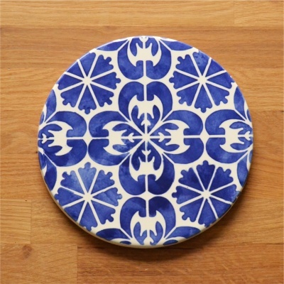 Prato redondo em cerâmica azul e branca com padrão geométrico e floral