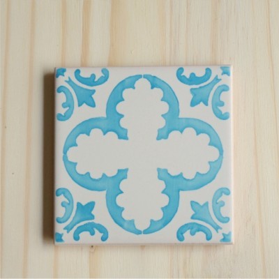 Azulejo cerâmico quadrado azul e branco com padrão floral em madeira clara