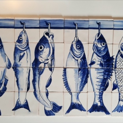 Painel de azulejos com peixes azuis pintados