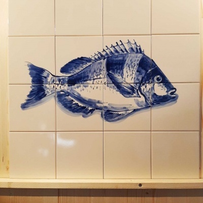 Azulejos cerâmicos brancos com desenho em azul de um peixe