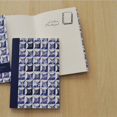 Dois cadernos com padrão azul e branco sobre mesa de madeira clara