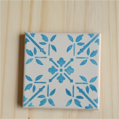 Azulejo branco com padrão azul de flores e folhas