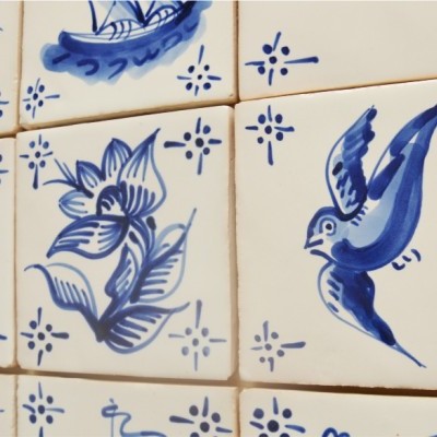 Azulejos brancos com desenhos azuis de peixe, planta e pássaro