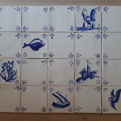 Azulejos cerâmicos brancos com desenhos azuis variados sobre mesa de madeira