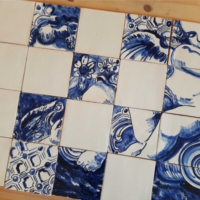 Azulejos quadrados cerâmicos azuis e brancos com vários padrões dispostos em madeira