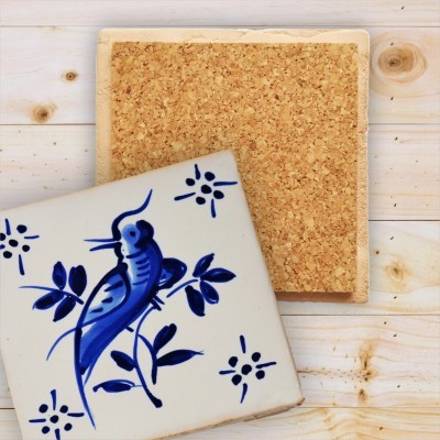 Dois azulejos quadrados, um com cortiça e outro com desenho azul de pássaro