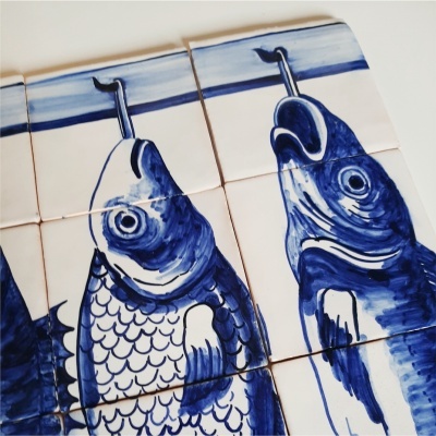 Azulejos azuis e brancos com desenho de peixe pendurado em gancho
