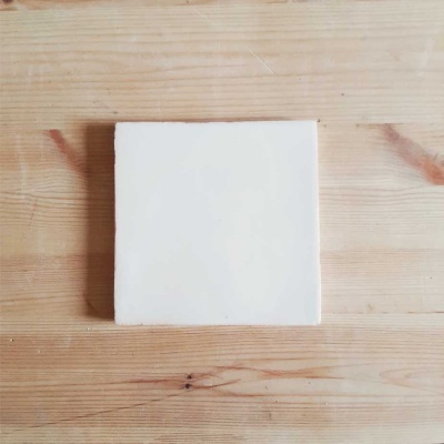 Placa branca quadrada sobre superfície de madeira