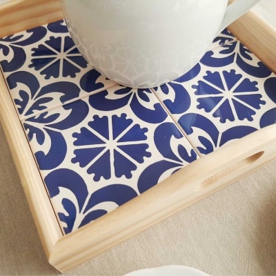 Tabuleiro de madeira clara com azulejos cerâmicos azuis e brancos decorativos