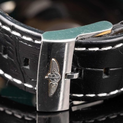 Correa preta de relógio em pele com fivela metálica prateada e costuras brancas