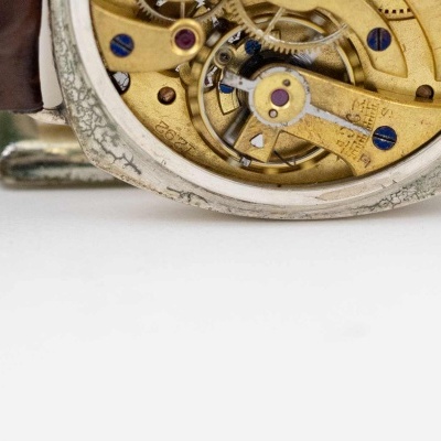 Relógio de pulso com mecanismo interno visível e correia castanha