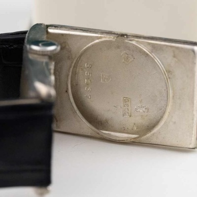 Cinta preta com padrão pele crocodilo e fivela metálica prateada com inscrições