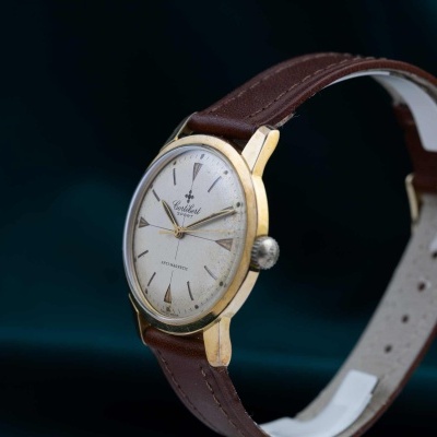 Relógio de pulso com caixa dourada e pulseira castanha